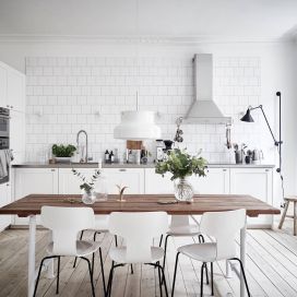 Celá biela škandinávska kuchyňa s dreveným stolom